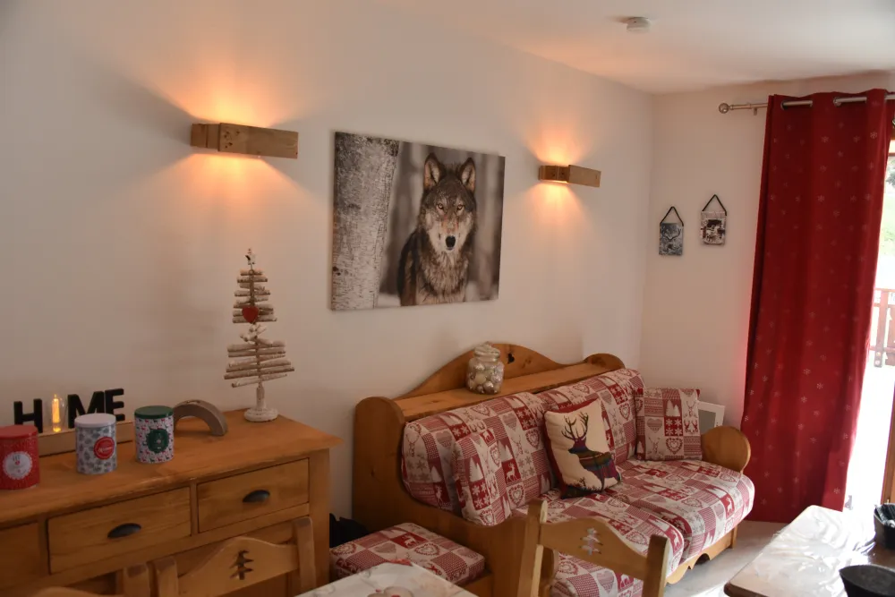 Joli salon, séjour décoré selon le thème du loup. Canapé convertible.