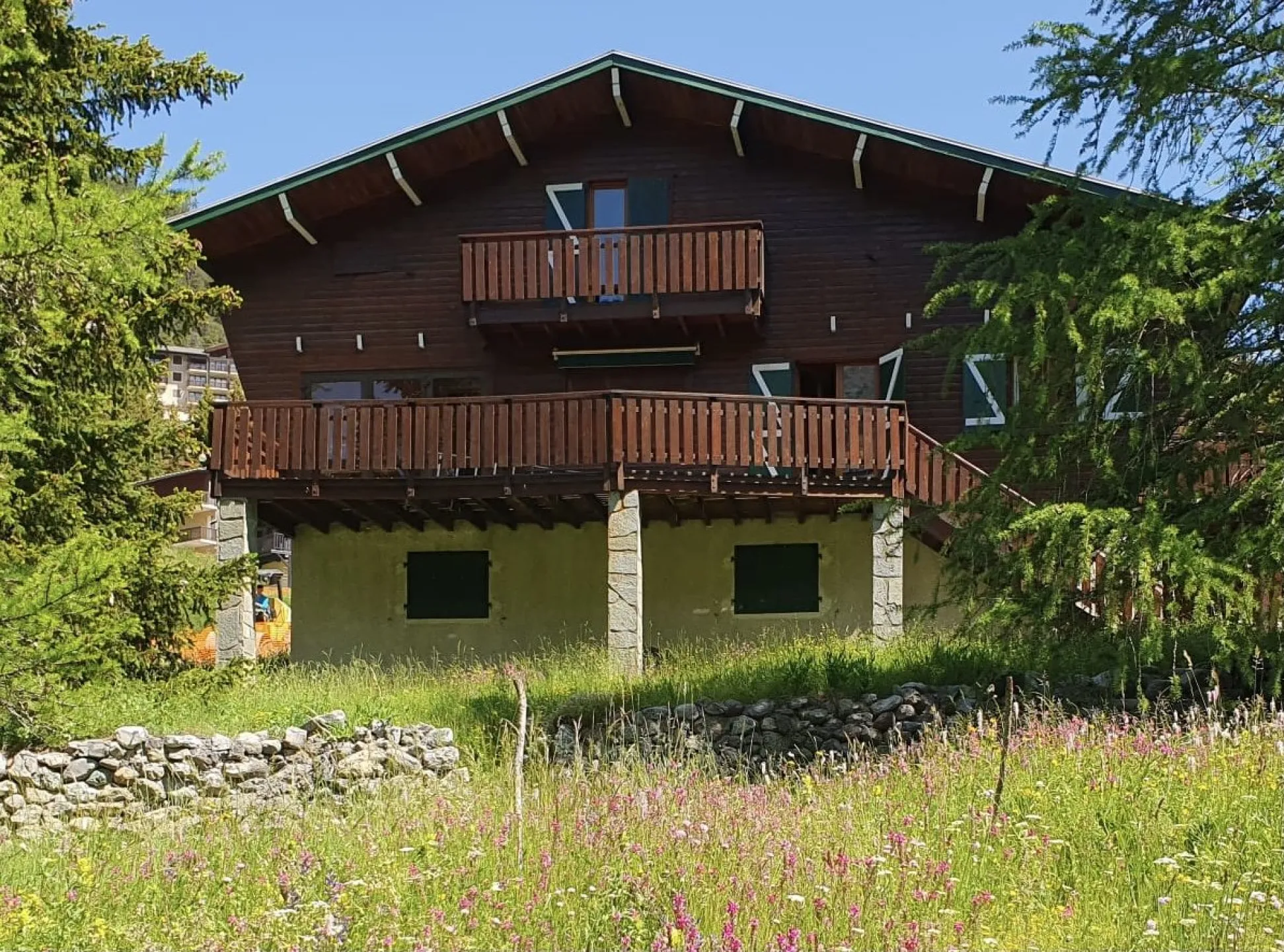 Le chalet dans son écrin fleuri au printemps.