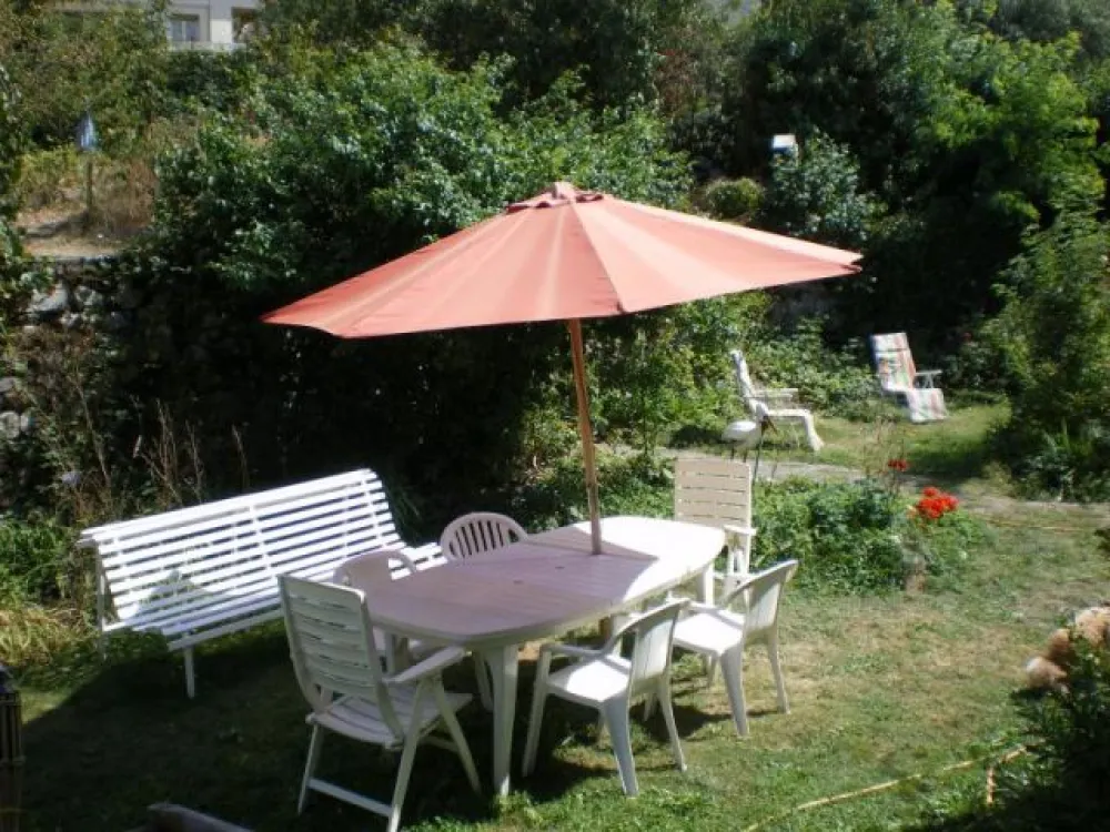 jardin avec ses salons de jardin - barbecue -chaises longues .