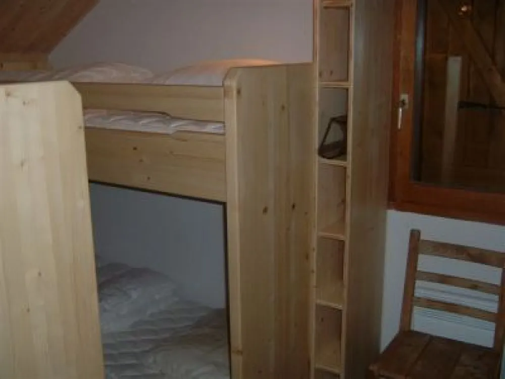 La chambre des enfants avec deux fois deux lits superposés, une armoire de rangement en plus des petits casiers,  ainsi qu'un  bureau. 