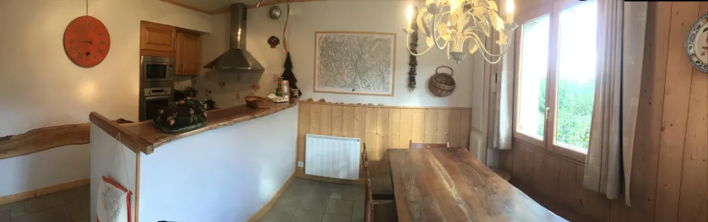 Cuisine avec son bar en noyer et la grande table de la salle à manger