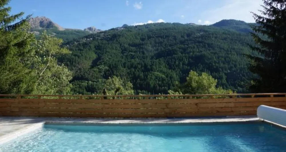 De la terrasse de la piscine, vue sur Serre Chevalier et le nouveau télécabine de Chantemerle, juste en face