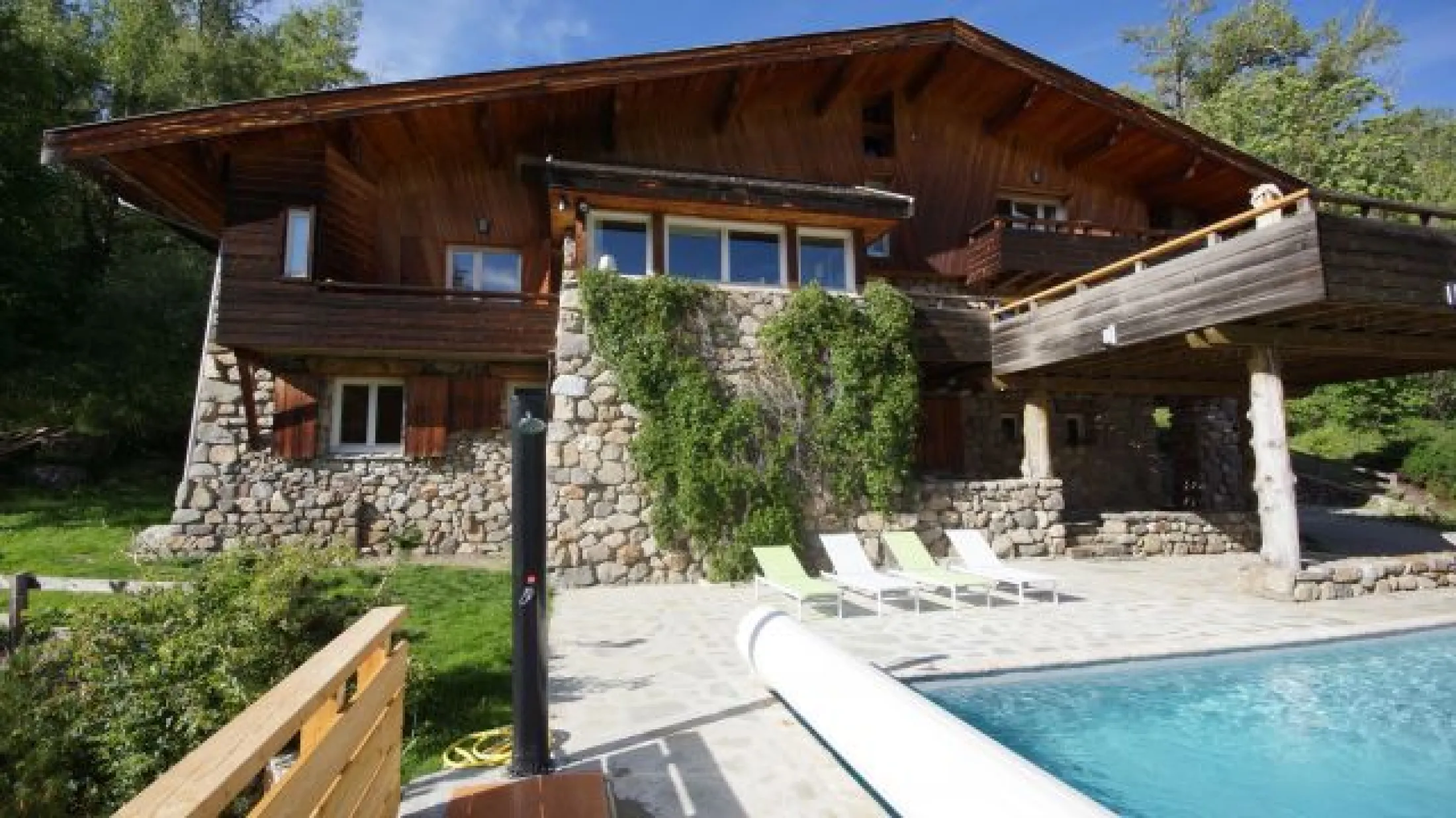 Le chalet en pierre de la Guisane, la rivière qui coule dans la vallée, et en Mélèze.
Une grande battisse, de prés de 25 M de long à la toiture débordante, avec sa terrasse sur le séjour-salon, surplombant la piscine d'été.
