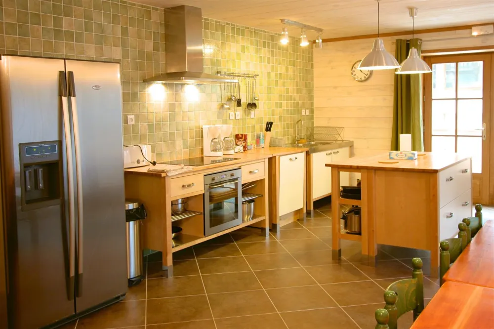 Cuisine bien équipée et coin repas pour 14 personnes.