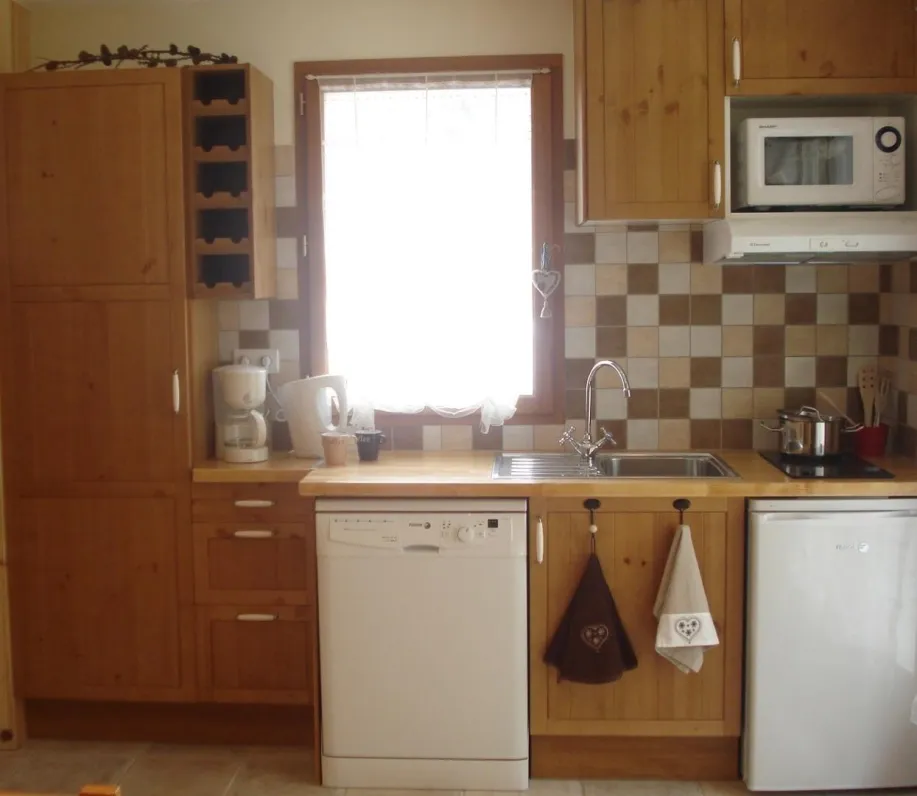 coin cuisine de la location Casareva aménagé avec micro-ondes grill, lave-vaisselle, hotte, plaques vitro, cafetière, bouilloire, frigo table top et vaisselle assortie ...