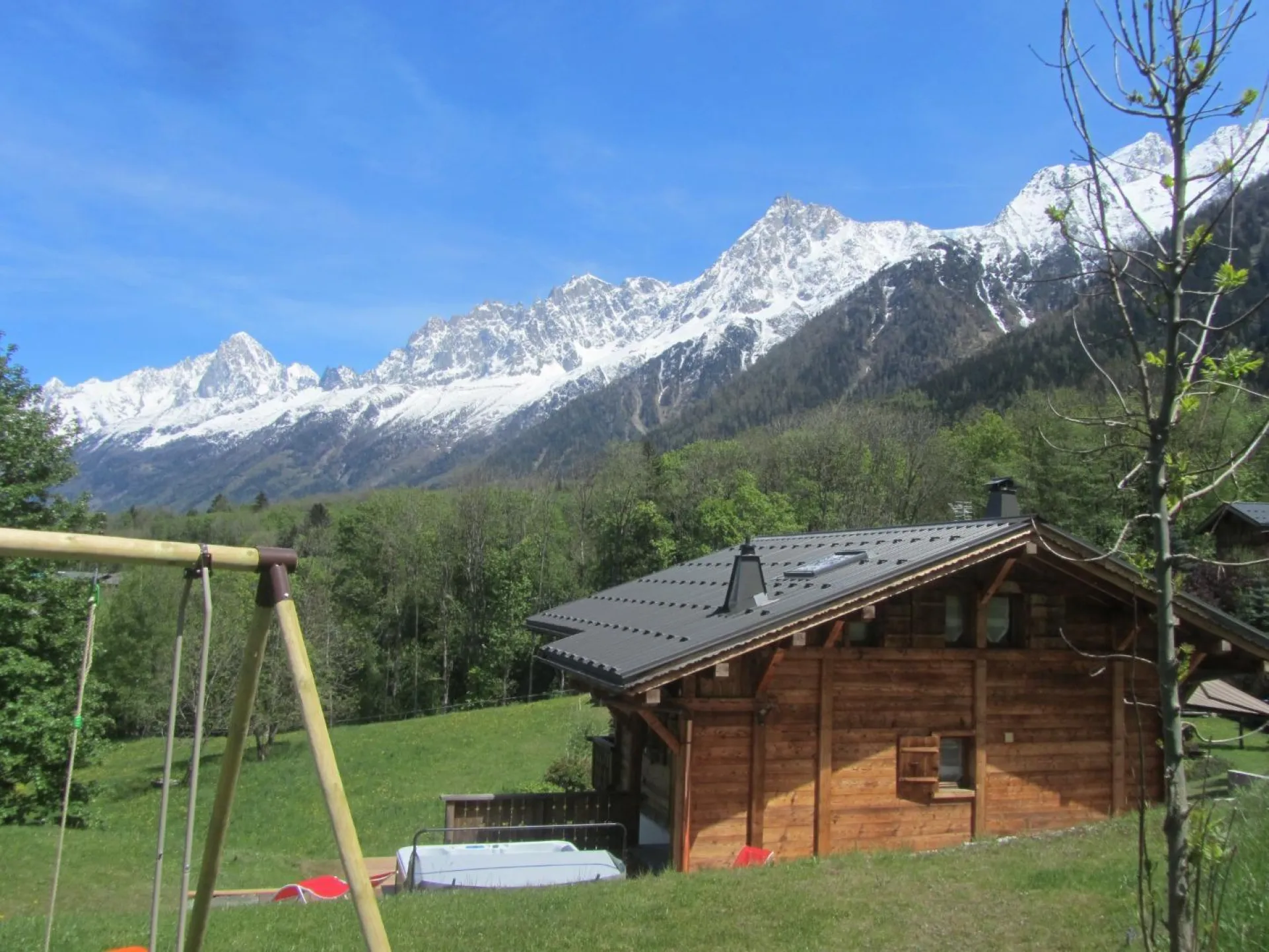 CE CHALET 4* ET DE TOUT CONFORT AVEC SON SPA chauffé toute l année sur une vue imprenable sur toute la chaine du mt blanc grand jardin au calme belle  terrasse en pierre . Table chaise . Une autre terrasse en bois  avec chaise longue   tout pour passé un 