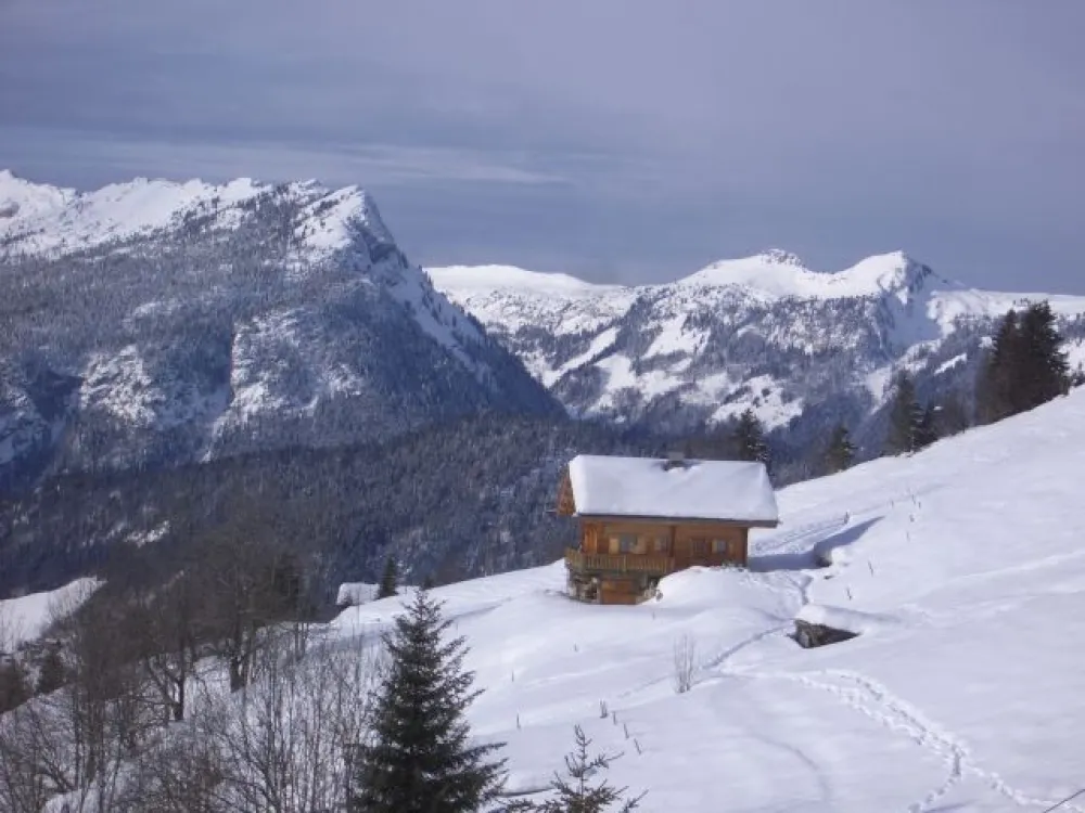 chalet en hiver au fond le lachat de thones et les montagnes des Auges les Glieres (ouest)