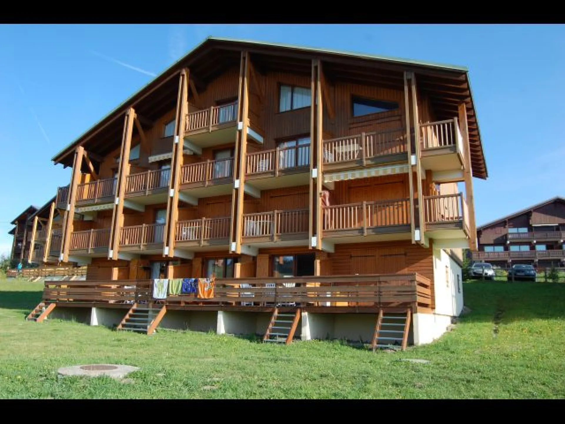vue cu Cristal 2 en été. l'appartement qui se situe au rez de chaussée,se trouve au centre, avec accès sur extérieur par escalier au premier plan.