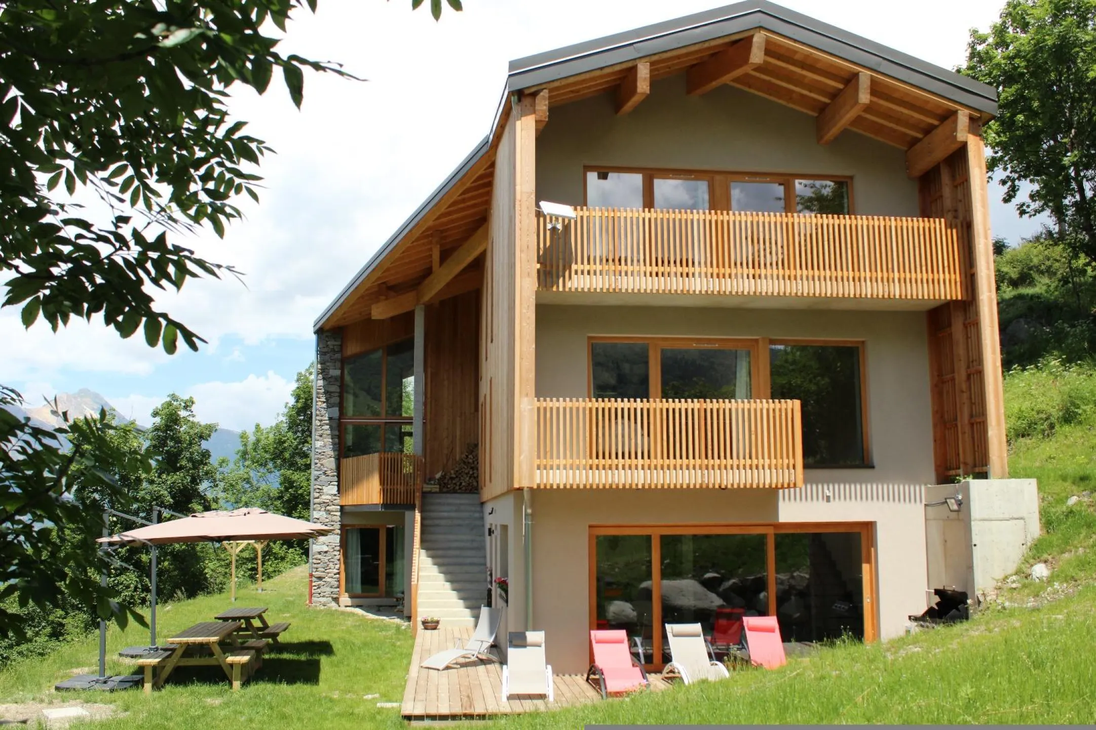 Le chalet prêt pour recevoir ses invités cet été avec son barbecue, ses tables de picnic avec parasols et ses transats. 