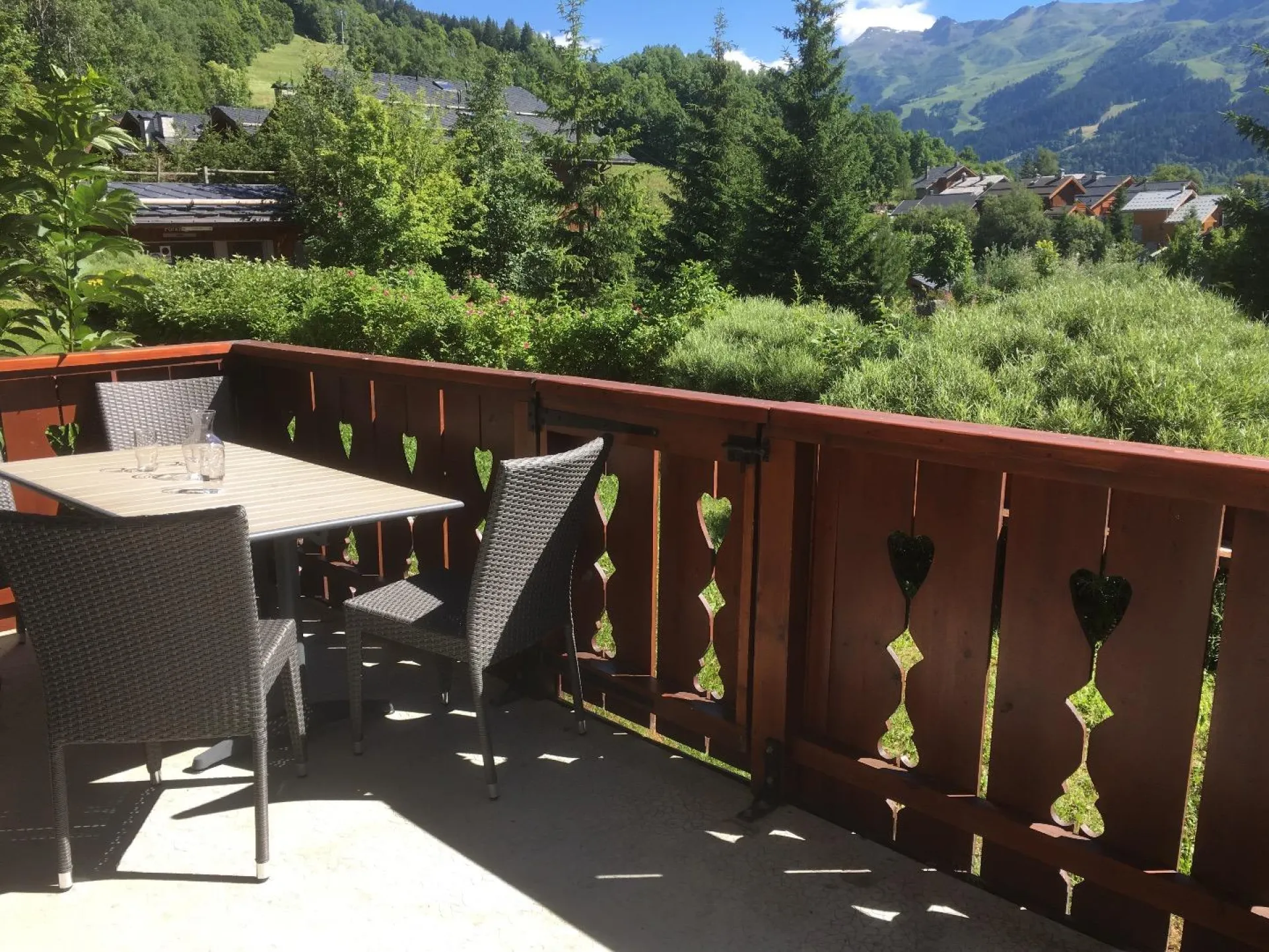 En été : Terrasse plein sud et retour sud-ouest avec portillon d'accès sur pelouse. 