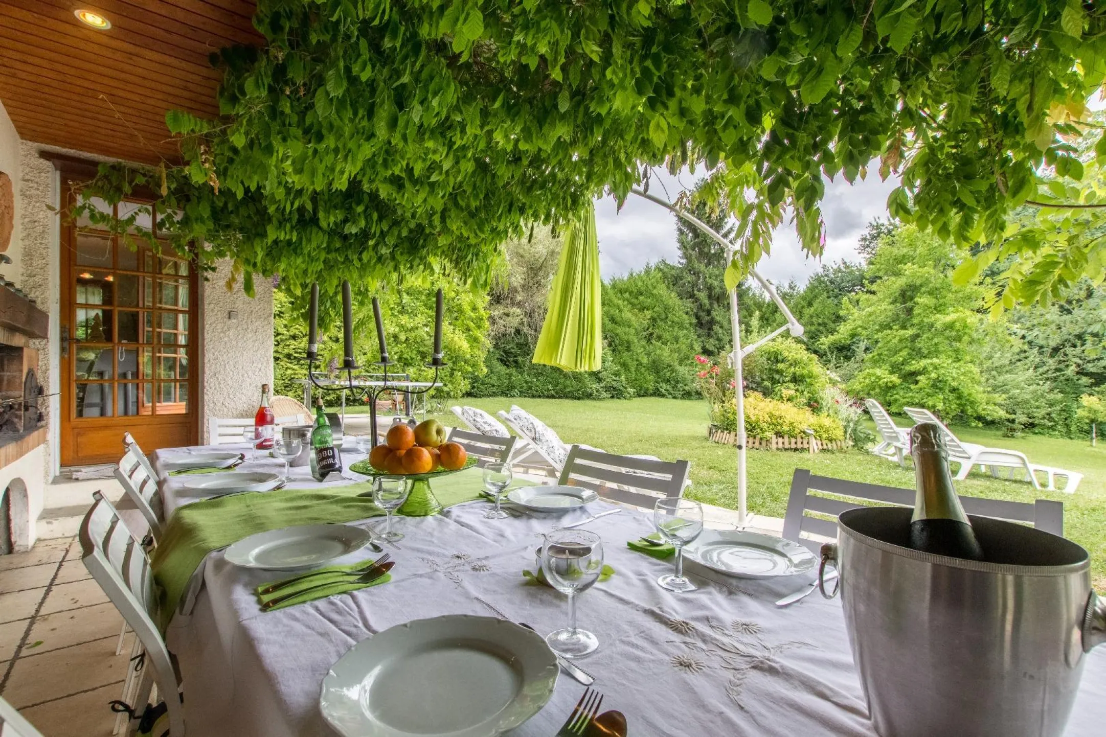 Une vaste terrasse ombragée par la glycine ouvrant sur le grand jardin