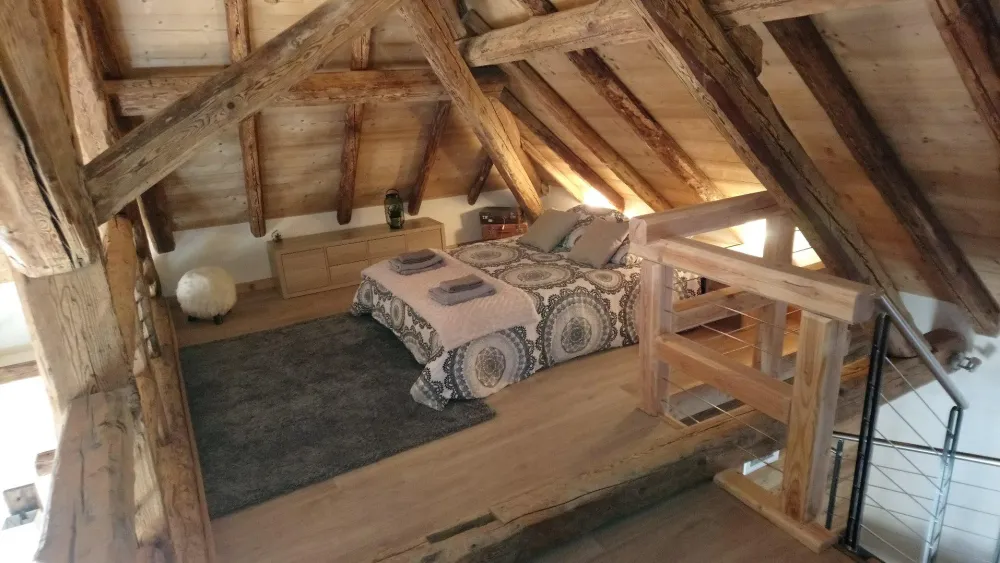Mezzanine sous charpente avec lit double et deux futon à lattes convertible. Un coin très cosy et modulable si besoin.