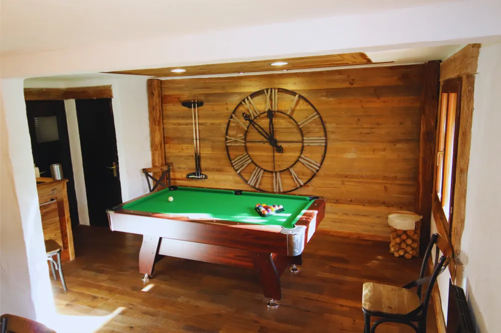 Profitez de notre superbe billard au cœur d'un espace de vie habillé de vieux bois authentique.