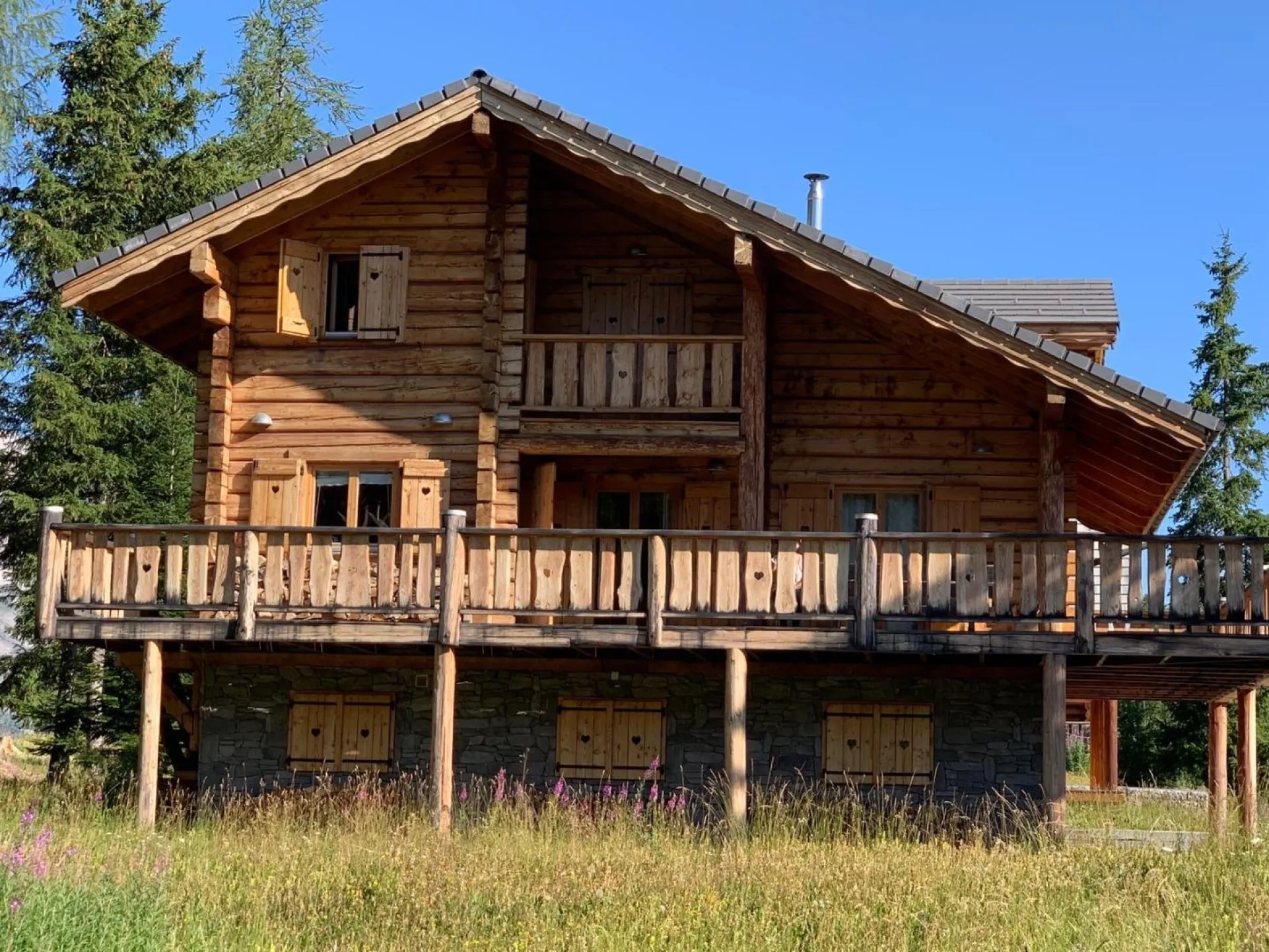 Un grand terrain se situe devant le chalet donnant une vue dégagée sur les différents massifs 