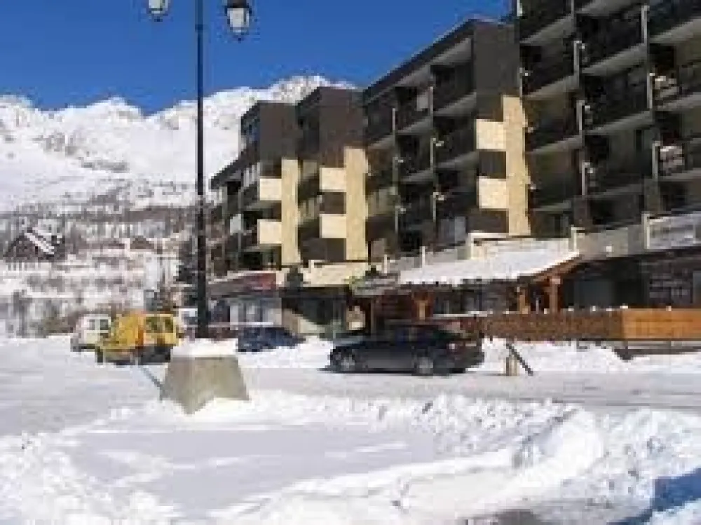 Devant la résidence, avec le grand parking public.