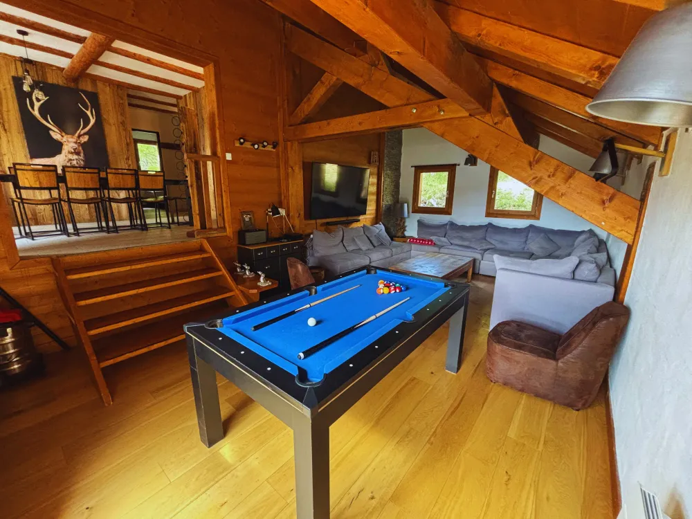 Notre grand espace de vie au niveau intermédiaire : un salon avec canapé en U, un billard chaleureux et une salle à manger lumineuse.