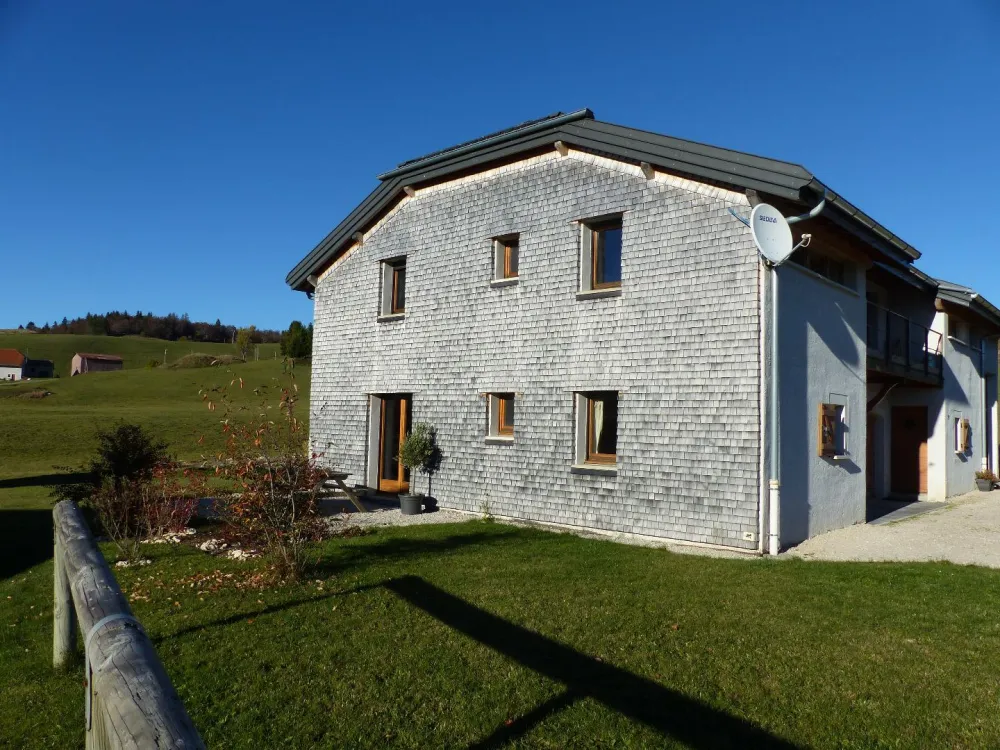 Façade et terrasse du gîte en automne.
